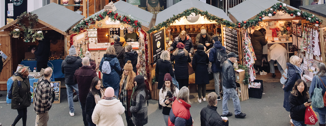 A row of chalets with visitors exploring the market